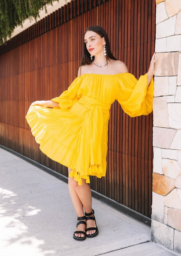 Yellow knee-length dress with long sleeves with tassel belt front campaign